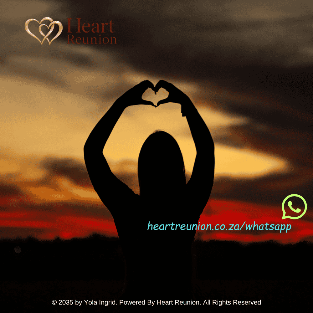A person forms a heart shape with their hands against a warm sunset.